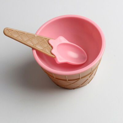 As crianças copos do gelado com o plástico da colher reusável