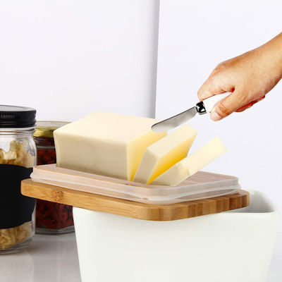 Prato de manteiga cerâmico branco com tampa e faca para o contador de cozinha