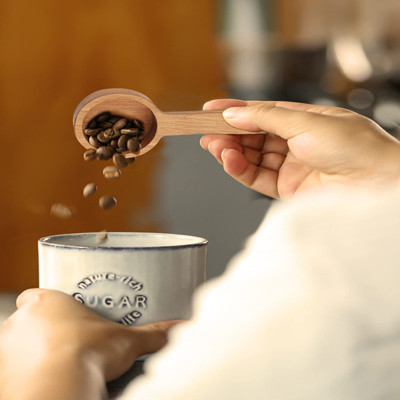 Colher de café de madeira da cor de madeira que mede para feijões de café