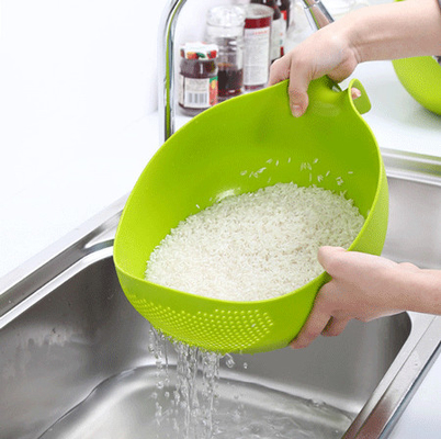 Bacia plástica do filtro do arroz com a cozinha do punho que drena escorredores para vegetais de limpeza