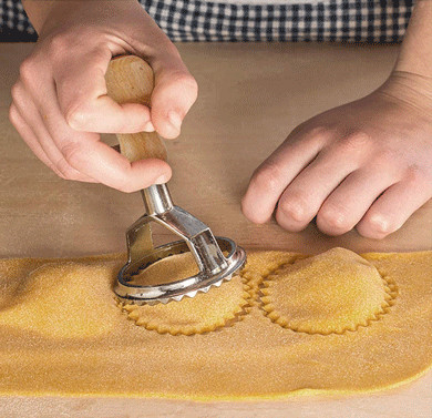 Molde de aço inoxidável do ravioli com o punho de madeira usado fazendo bolinhas de massa italianas