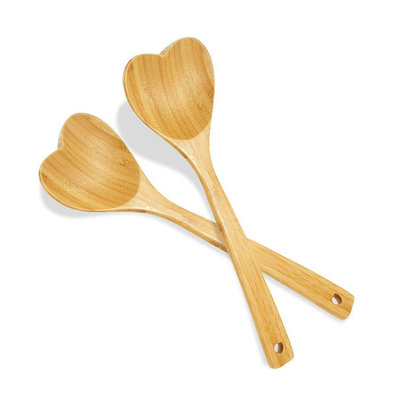 O coração de madeira deu forma à colher de bambu gravada cozinhando a colher de amor