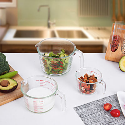 Copo de medição de vidro de cozimento da cozinha com gráficos vermelhos micro-ondas e forno